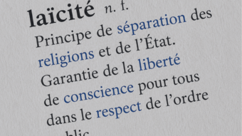 Gros plan sur une page de dictionnaire présentant la définition du mot « laïcité ». Les notions de séparation des religions et de l'État, de liberté de conscience et de respect de l'ordre public sont mises en évidence. 